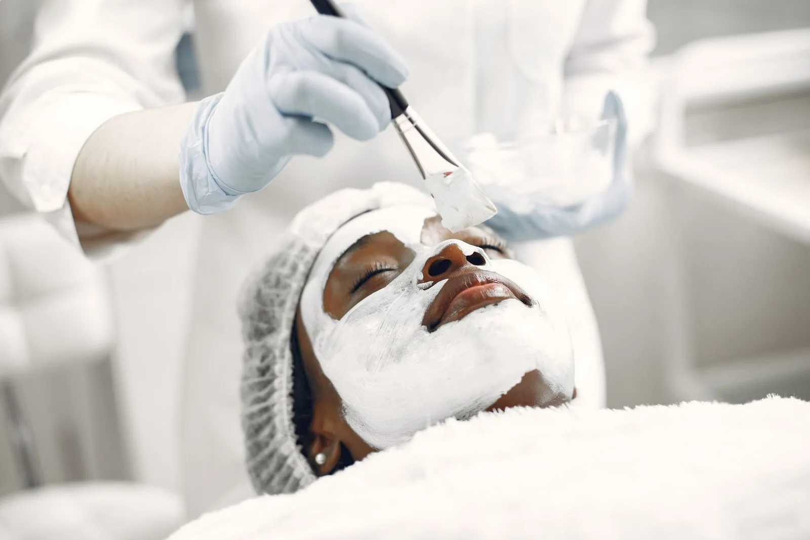 Esthetician applying a treatment mask